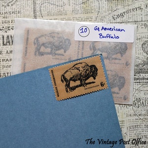 May include: A sheet of brown paper with 10 vintage American Buffalo stamps. The stamps are brown with a black outline of a buffalo. The text "Wildlife Conservation" and "United States 6c" are printed on the stamps. The sheet of stamps is on a blue background.
