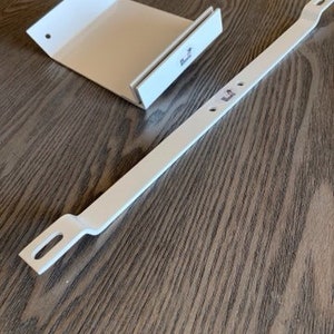 May include: White metal shelf bracket with two mounting holes and a white cardboard shelf support. The shelf support has a fold-over design and the text "Built-in" printed on it.