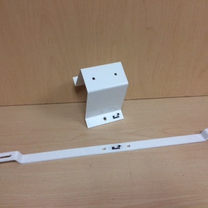 May include: White metal shelf bracket with two mounting holes and a logo. The bracket is attached to a long, white metal bar with two mounting holes and a logo.