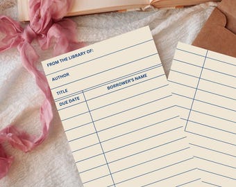 May include: Two rectangular library checkout cards made of cream-colored paper with dark blue printed lines and text. The cards feature the headers FROM THE LIBRARY OF, AUTHOR, TITLE, BORROWER'S NAME, and DUE DATE, with multiple horizontal lines for writing.
