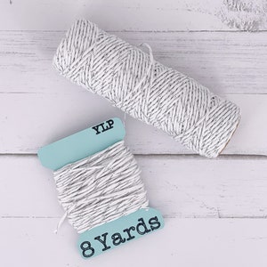May include: A spool of white twine with silver flecks, labeled "YLP" and "8 Yards" on a light blue label.