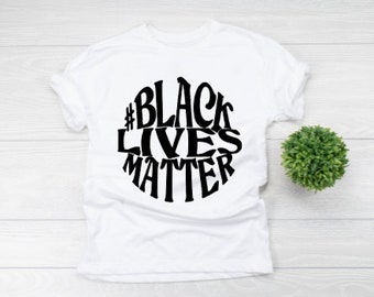 May include: White t-shirt with a black circle graphic that says "#Black Lives Matter" in a stylized font.