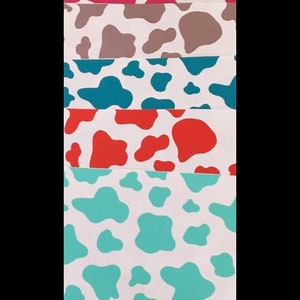 May include: A set of six cow print fabric swatches in different colors, including pink, brown, teal, orange, and turquoise.