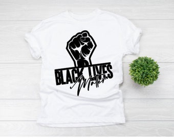 May include: White t-shirt with a black fist raised in the air and the text "Black Lives Matter" printed on it.