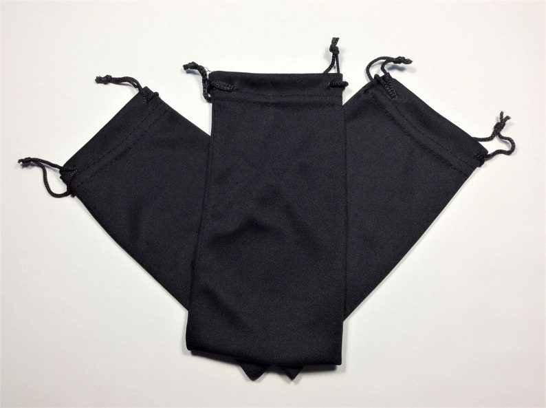 May include: Three black drawstring pouches made of soft fabric. The pouches are folded and stacked on top of each other.