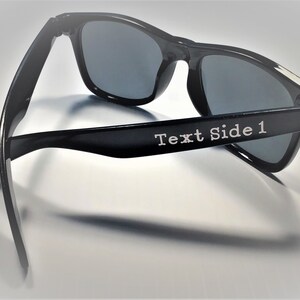 May include: Black sunglasses with a dark gray lens. The sunglasses have the text "Text Side 1" on the side.