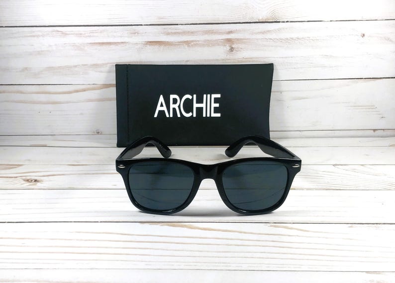 May include: Black sunglasses with a black case that says "ARCHIE" on it.