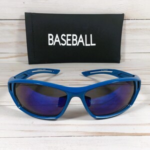 May include: Blue sports sunglasses with dark lenses. The sunglasses have a sporty design and are paired with a black case that reads "BASEBALL" in white letters. The sunglasses are designed for UV protection.