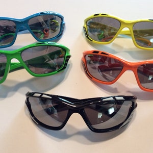 May include: Four pairs of sunglasses with different colored frames: blue, green, orange, and black. All sunglasses have a similar style with a sporty design and gray lenses.