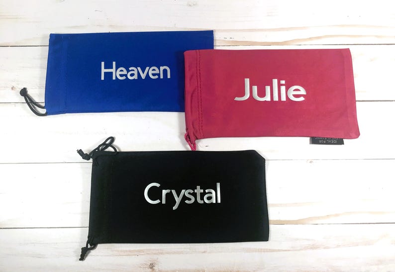 May include: Three drawstring bags with different names embroidered on them. The bags are blue, pink, and black.