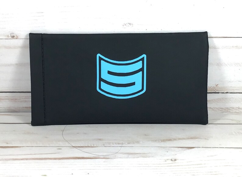 May include: Black rectangular case with a blue logo of a stylized letter "S" inside a curved shape.