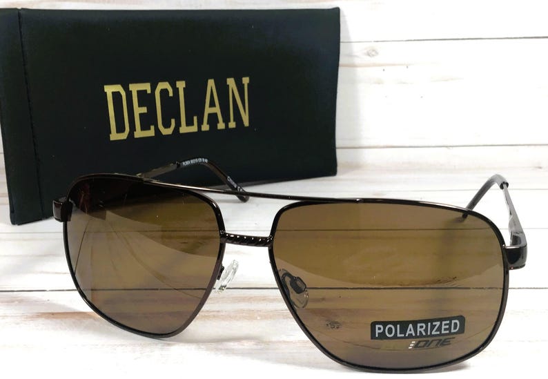 May include: Brown polarized sunglasses with a black frame and the word "DECL&Aacute;N" printed on the case.