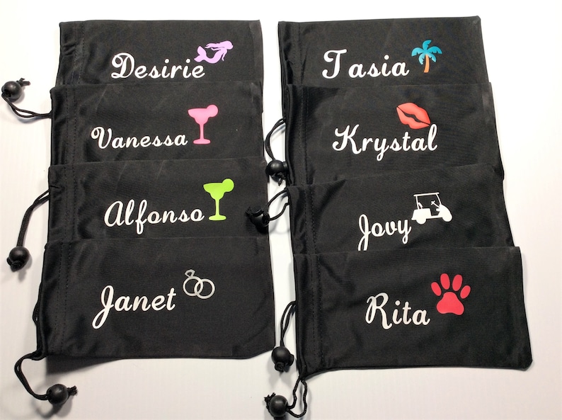 May include: Eight black drawstring bags with white embroidered names and various colored icons. The names are:  Desiree, Vanessa, Alfonso, Janet, Tasia, Krystal, Jovy, and Rita.