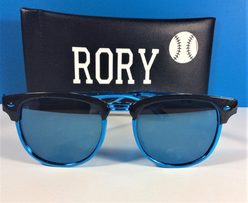 May include: Blue mirrored sunglasses with black frames and a black case with the word "RORY" and a baseball graphic.