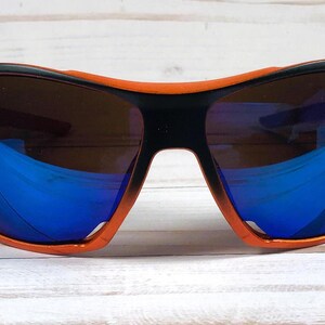 May include: Orange and black wraparound sunglasses with blue mirrored lenses.