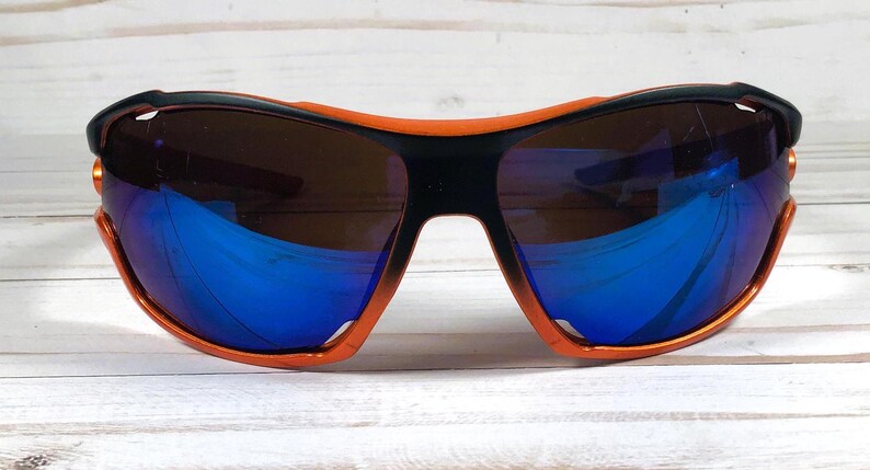 May include: Orange and black wraparound sunglasses with blue mirrored lenses.
