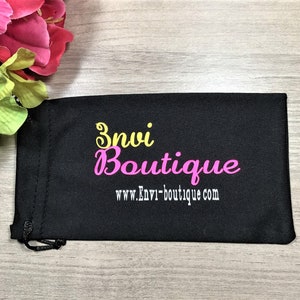 May include: Black drawstring bag with the text "Envi Boutique" and the website address "www.Envi-boutique.com" in yellow and pink lettering.