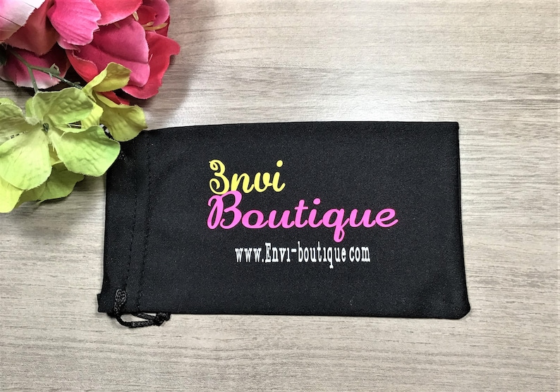 May include: Black drawstring bag with the text "Envi Boutique" and the website address "www.Envi-boutique.com" in yellow and pink lettering.
