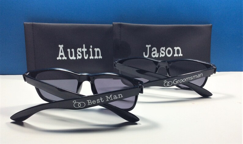 May include: Two pairs of black sunglasses with personalized engravings. One pair says "Austin Best Man" and the other says "Jason Groomsman".