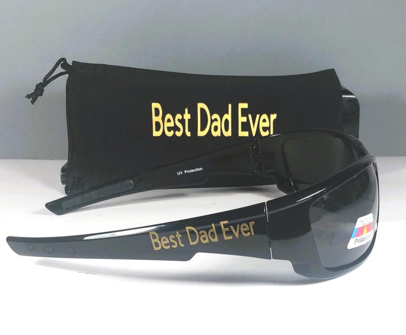 Puede incluir: Gafas de sol negras con lentes oscuras y el texto Best Dad Ever impreso en dorado en la patilla. Detr&aacute;s de las gafas hay una bolsa negra con cord&oacute;n a juego, que tambi&eacute;n presenta el texto Best Dad Ever en letras doradas.