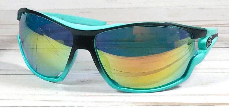 May include: A pair of black and turquoise sunglasses with a mirrored lens. The sunglasses have a sporty design and are ideal for outdoor activities.