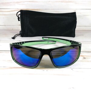 May include: Black and green sunglasses with blue reflective lenses and a black drawstring pouch. The sunglasses have a rectangular frame with green accents. The word "POLARIZED" is printed on the lens.