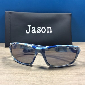 May include: Blue and white camouflage sunglasses with a black case that says "Jason" on it.
