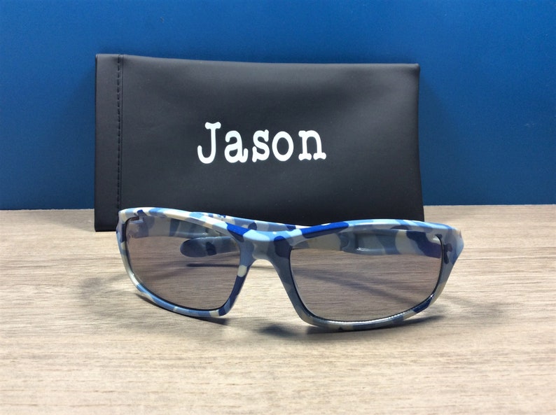 May include: Blue and white camouflage sunglasses with a black case that says "Jason" on it.