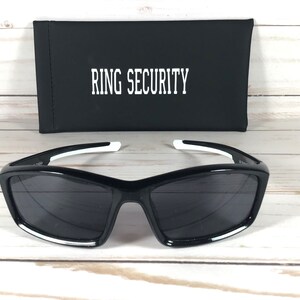 May include: Black sunglasses with white accents and a black case that says "RING SECURITY" on it.