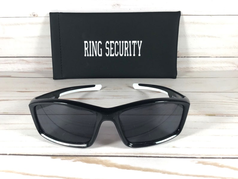 May include: Black sunglasses with white accents and a black case that says "RING SECURITY" on it.