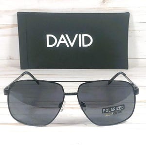 May include: Black aviator sunglasses with a black frame and dark gray lenses. The sunglasses have the word "DAVID" printed on the case and "POLARIZED" printed on the lenses.