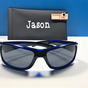 May include: Blue sunglasses with a black case that says "Jason" on it. The case also has a small tag that says "birthday bash" with colourful stars.