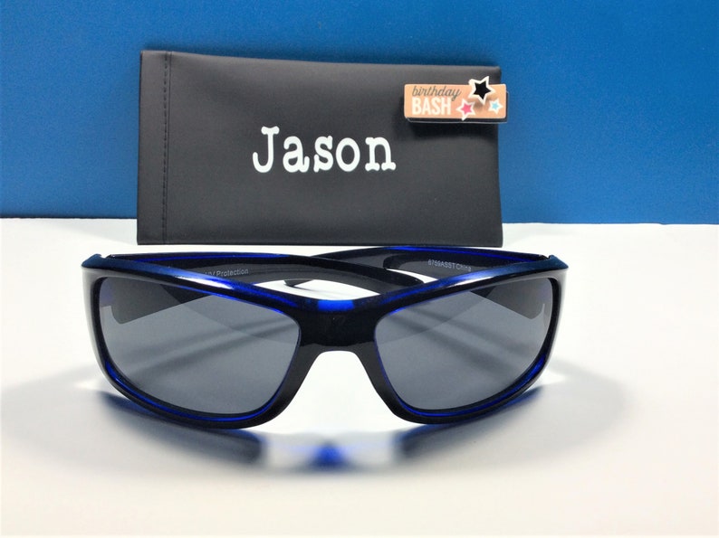 May include: Blue sunglasses with a black case that says "Jason" on it. The case also has a small tag that says "birthday bash" with colourful stars.