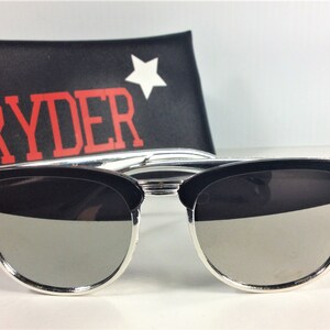 May include: Black sunglasses with silver trim and mirrored lenses. The sunglasses are in a black case with the word "RYDER" in red letters and a white star.