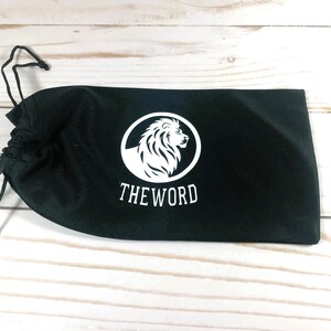 May include: Black drawstring bag with a white lion logo and the text "THE WORD" printed on the front.
