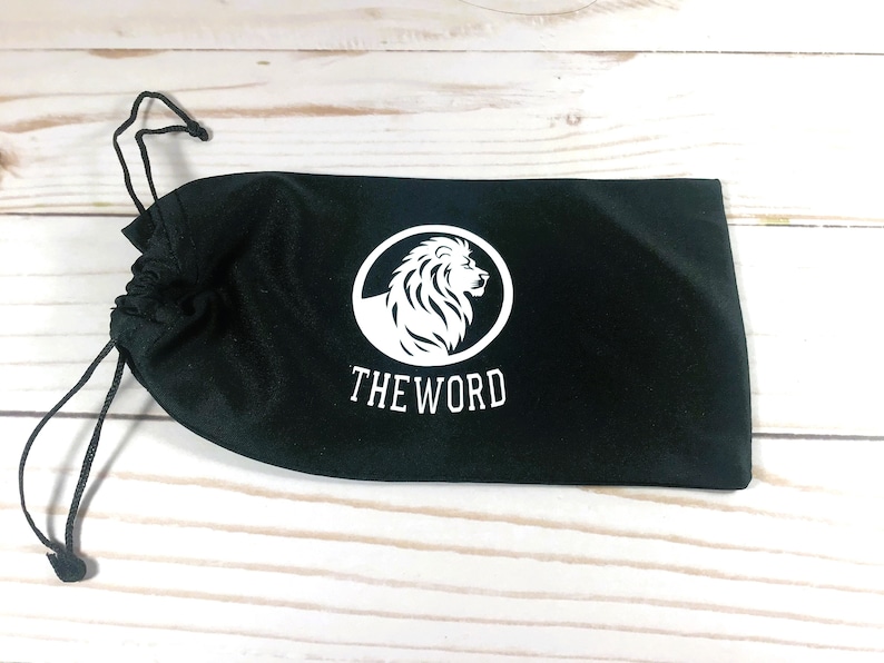 May include: Black drawstring bag with a white lion logo and the text "THE WORD" printed on the front.