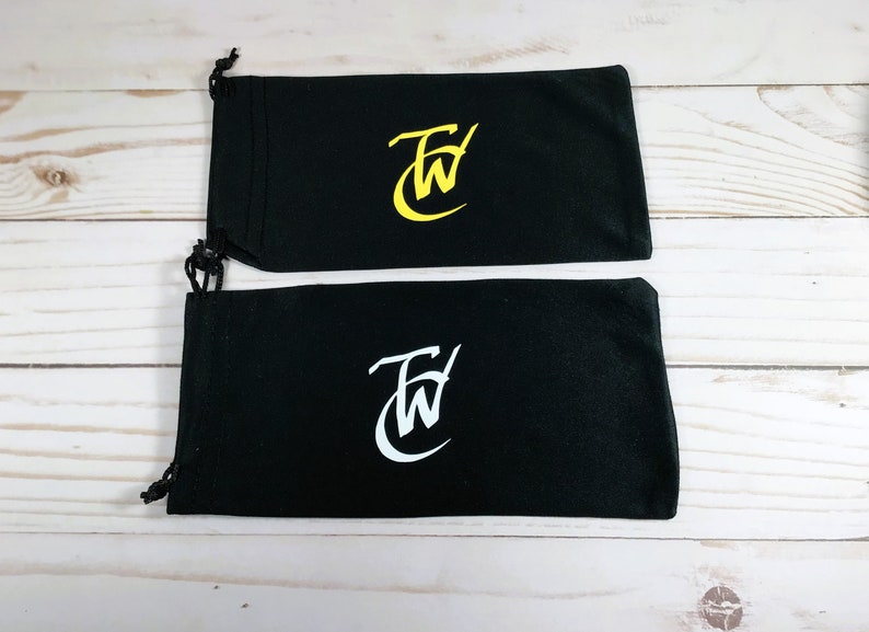 May include: Two black drawstring pouches with a white "FW" logo. The top pouch has a yellow logo and the bottom pouch has a white logo.