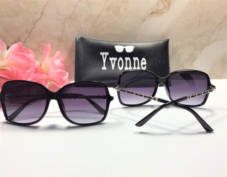 May include: Black sunglasses with a silver chain detail on the arms. The sunglasses are in a case with the word "Yvonne" printed on it.
