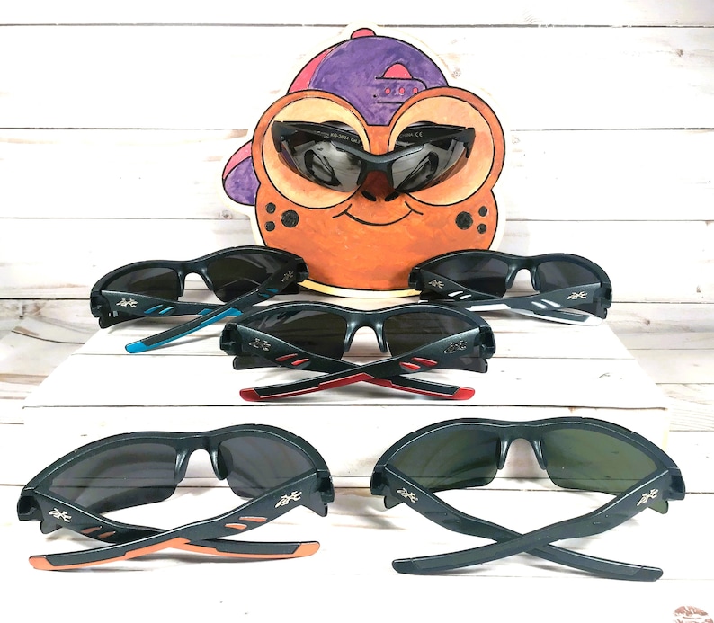 K&ouml;nnte beinhalten: F&uuml;nf Paar schwarze Sonnenbrillen mit verschiedenen farbigen Akzenten an den B&uuml;geln. Die Sonnenbrillen haben ein sportliches Design mit einem gebogenen Rahmen und schwarzen Gl&auml;sern.
