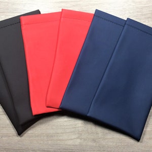 May include: Five fabric pouches in different colors: black, red, blue, and two more blue pouches. The pouches are made of a smooth, soft fabric and have a simple, rectangular shape.