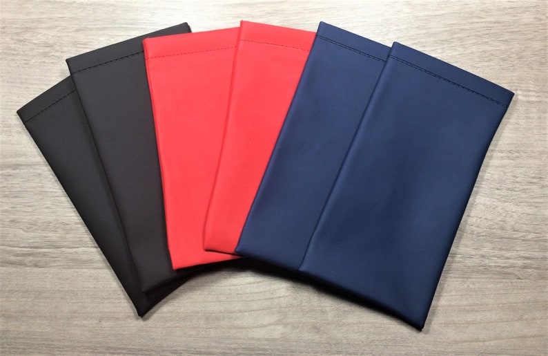 May include: Five fabric pouches in different colors: black, red, blue, and two more blue pouches. The pouches are made of a smooth, soft fabric and have a simple, rectangular shape.