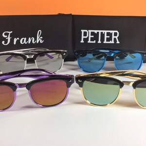 May include: Four pairs of sunglasses with different colored lenses and frames. The sunglasses are arranged in a row on a white surface. The sunglasses are labeled "Frank" and "PETER".