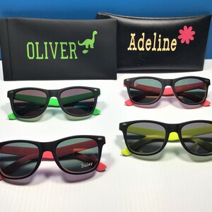 May include: Three pairs of black sunglasses with different coloured frames. The sunglasses have black lenses and are labelled "Oliver", "Adeline", and "Bailey".
