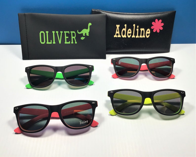May include: Three pairs of black sunglasses with different coloured frames. The sunglasses have black lenses and are labelled "Oliver", "Adeline", and "Bailey".
