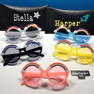 Puede incluir: Cuatro pares de gafas de sol arco&iacute;ris con lentes de diferentes colores. Las gafas tienen un dise&ntilde;o de arco&iacute;ris con nubes en la parte superior de las monturas. El texto "Nombre grabado GRATIS" es visible en la esquina inferior derecha de la imagen.