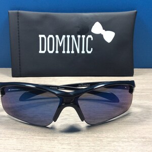 May include: Black sunglasses with a dark blue gradient lens and a black case with the word "DOMINIC" printed in white.