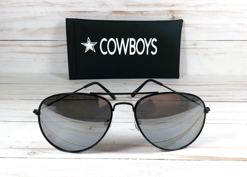 May include: Black aviator sunglasses with mirrored lenses and a black case that says "COWBOYS" in white lettering.