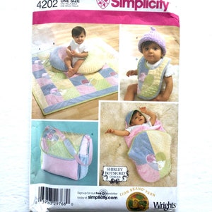 May include: Simplicity sewing pattern number 4202, one size, for a baby quilt, diaper bag, and bib. The pattern features a patchwork design with pink, green, and blue fabrics. The pattern is titled "Shirley Botsford Designs" and includes instructions for making a baby quilt, diaper bag, and bib.