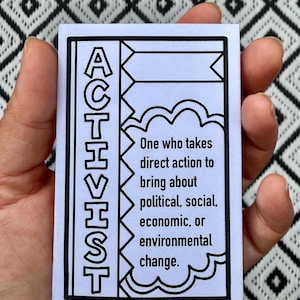 Puede incluir: Una tarjeta rectangular blanca con borde negro que presenta la palabra ACTIVIST escrita verticalmente en fuente negrita. A la derecha, un gr&aacute;fico en forma de nube contiene el texto: One who takes direct action to bring about political, social, economic, or environmental change.