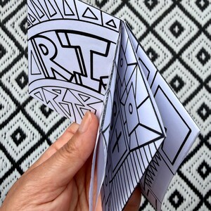 Puede incluir: Un folleto de papel blanco con dise&ntilde;os de l&iacute;neas en tinta negra. La portada presenta la palabra ART en letras may&uacute;sculas negritas rodeada de patrones geom&eacute;tricos. Las p&aacute;ginas interiores muestran varias formas abstractas, l&iacute;neas y s&iacute;mbolos.